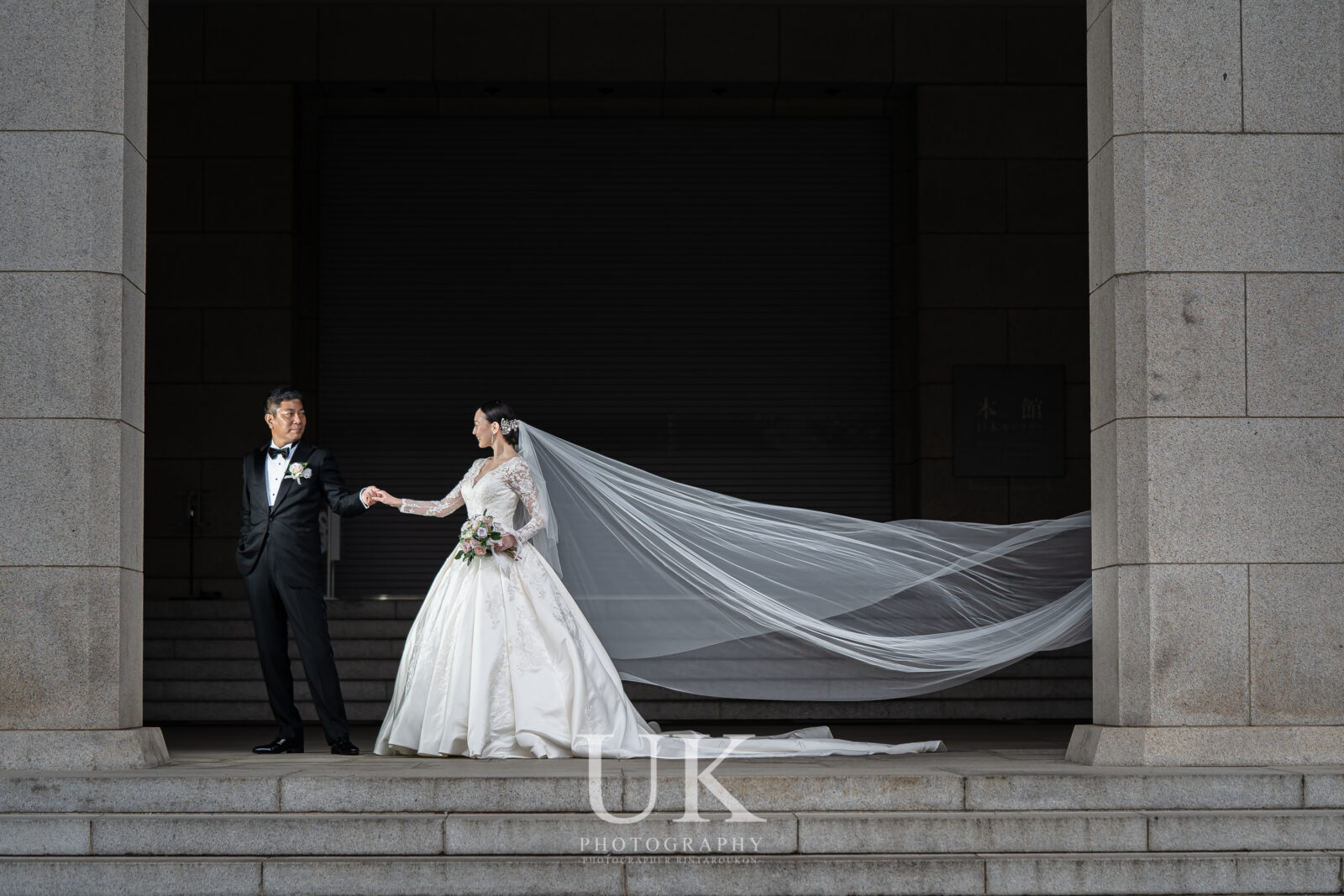 東京国立博物館の本館入口でロングベールをなびかせる新郎新婦